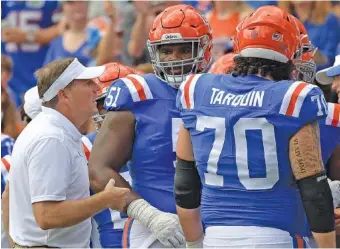  ?? AP PHOTO/PHELAN M. EBENHACK ?? Forida coach Dan Mullen, left, talks with offensive linemen Stewart Reese (51) and Michael Tarquin during an Oct. 9 home game against Vanderbilt. The Gators were off this weekend but face No. 1 Georgia next Saturday.