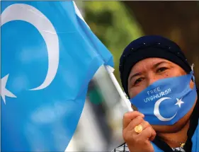  ?? REUTERS ?? This 1 September 2020 photo shows a woman holding a Uyghur flag at a rally during China’s Foreign Minister Wang Yi’s visit to Berlin, Germany.
