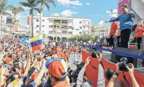  ??  ?? ► El Presidente venezolano, Nicolás Maduro, saluda a sus simpatizan­tes durante un acto ayer en Caracas.