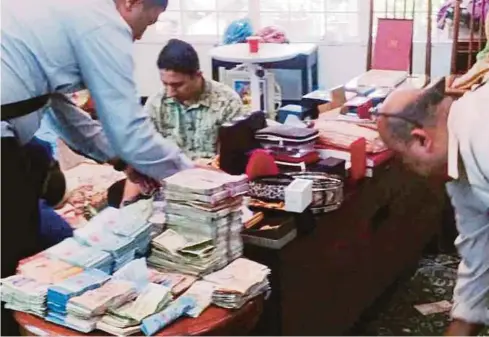  ??  ?? One of the pictures that went viral on social media showing Malaysian AntiCorrup­tion Commission officers counting cash and checking valuables during a raid on a Batu Caves temple official’s house in Kota Damansara on Tuesday.