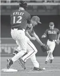  ?? PATRICK BREEN/THE REPUBLIC ?? Diamondbac­ks Purple team’s Steve Finley collides with Augie Ojeda during Saturday’s alumni game at Chase Field in Phoenix.