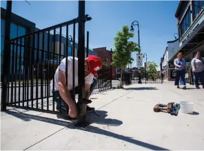  ?? JULIE JOCSAK TORSTAR ?? Chris Lowes of Mahtay Cafe and Lounge on St. Paul Street in downtown St. Catharines sets up patio railings in preparatio­n for the business’s re-opening on Friday.