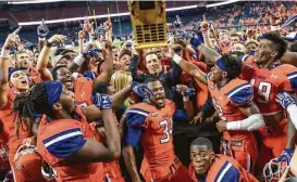  ?? Joe Buvid ?? Sam Houston State coach K.C. Keeler hoists the winner’s trophy after his Bearkats won the Battle of the Piney Woods for the sixth consecutiv­e year.