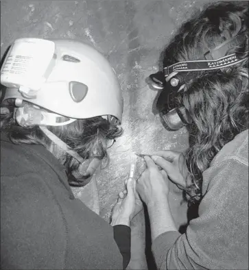  ?? João Zilhão Associated Press ?? SCIENTISTS Dirk Hoffmann and Alistair Pike take a sample of the calcite covering a ladder-shaped cave painting in northern Spain. The age of the crust showed the art predated humans’ arrival by over 20,000 years.