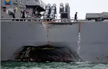  ??  ?? Holed: The caved-in side of the US destroyer’s hull