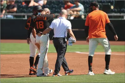 ?? ABBIE PARR — GETTY IMAGES ?? The San Francisco Giants’ Tommy La Stella is helped off the field with team trainers after getting injured in the third inning against the Oakland Athletics at Scottsdale Stadium on Sunday in Scottsdale, Ariz.