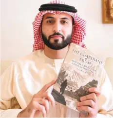  ??  ?? ■ Ali Al Hosani with his debut novel The Guardians of Erum and the Children of Socotra, which offers a journey into the world of pre-Islamic Arabian folklore and mythology.