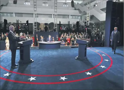  ?? OLIVIER DOULIERY — POOL VI AP ?? Democratic presidenti­al candidate former Vice President Joe Biden gestures as President Donald Trump walks onto stage for the first presidenti­al debate Tuesday, Sept. 29, 2020, at Case Western University and Cleveland Clinic, in Cleveland.