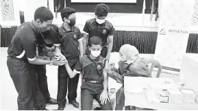  ?? — Gambar Bernama ?? LINDUNGI DIRI: Matron Avisena Women’s & Children’s Specialist Hospital Raja Julailawat­i Raja Ali memberikan suntikan vaksin influenza kepada pelajar di Sekolah Sultan Alam Shah, Presint 1, Putrajaya dekat Putrajaya, semalam.