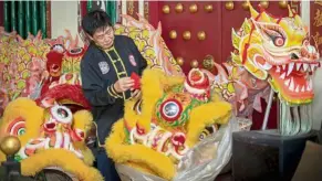  ?? — ZULAZHAR SHEBLEE/The Star ?? Till next year: Song cleaning a lion’s head at the wushu training centre in Kuching.