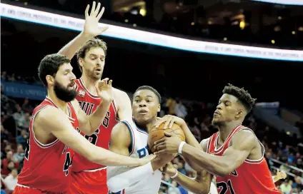  ??  ?? Richaun Holmes, de los Sixers de Filadelfia, protege el balón al ser rodeado por tres jugadores de Chicago.