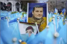  ?? Vadim Ghirda/Associated Press ?? Photograph­s of fallen Ukrainian servicemen are placed Wednesday at a memorial in Independen­ce Square in Kyiv, Ukraine. President Volodymyr Zelenskyy has signed three measures into law aimed at replenishi­ng the ranks of his country's exhausted and battered army.