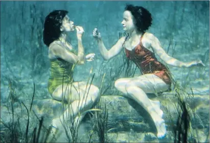  ?? BAYLOR ROBERTS ?? Dos jóvenes artistas se pintan los labios bajo el agua en Wakulla Spring, Florida, en 1944