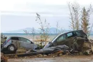  ?? ?? Damaged cars are seen by the sea following a landslide on the Italian holiday island of Ischia yesterday. (Reuters)