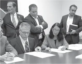  ?? AP Photo/Josh Repogle ?? ■ Susan Bucher, from right, Palm Beach County supervisor of elections, and Judge August Bonavita, seated center left, look at provisiona­l ballots Friday in Riviera Beach, Fla. A possible recount looms in a tight Florida gubernator­ial, U.S. Senate and agricultur­e commission race.