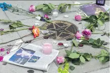  ?? JOSE LUIS MAGANA/THE ASSOCIATED PRESS ?? Flowers are placed around Prince’s star in a makeshift memorial on a sidewalk in Washington, D.C.