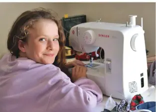  ??  ?? Cynane Branov, a Year 6 Melbourne schoolgirl, sits by her sewing machine while taking a break from making protective masks for hospitals and healthwork­ers hit by supply shortages.