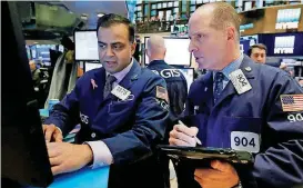  ?? [AP PHOTO] ?? Specialist Dilip Patel, left, and trader Michael Urkonis work on the floor of the New York Stock Exchange on Friday.