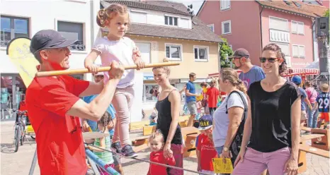  ?? FOTOS: WELSCH ?? Jochen Kucera, Leiter der Kinderspor­tschule und Initiator der Kinderolym­piade, hilft der kleinen Lara beim Balanciere­n auf dem Hochseil.