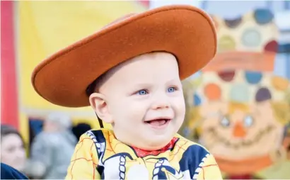  ??  ?? Ryker Holly, 8-months-old, grins and giggles in his Woody costume from “Toy Story” as he takes in the sights at Starkville Parks & Recreation's Hail-o-ween festival located at the Starkville Sportsplex. (Photo by Emma Moffett-taylor, SDN)