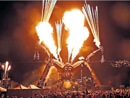  ??  ?? Artists rehearse for the Arcadia London 10th Anniversar­y Festival’s Metamorpho­sis show at Queen Elizabeth Olympic Park. The 50-ton Arcadia spider, built from repurposed military hardware, shoots out 50ft fireballs.