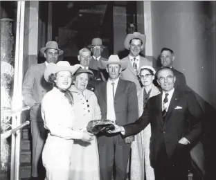  ?? Galt Archives photo 1975231327­5 LH ?? Rodeo Queen Mary Lynn Cook accepts a gift from Lethbridge Mayor A.W. Shacklefor­d during a send-off ceremony in October 1956.