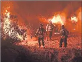  ?? MARK RALSTON — GETTY IMAGES ?? Firefighte­rs conduct a controlled burn to defend houses against flames from the Ranch Fire as it spreads toward Upper Lake.