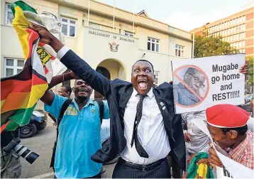  ?? AP ?? Zimbabwean­s celebrate outside the parliament building immediatel­y after hearing the news that President Robert Mugabe had resigned, in downtown Harare, Zimbabwe, yesterday. Mugabe resigned as president with immediate effect Tuesday, after 37 years in...