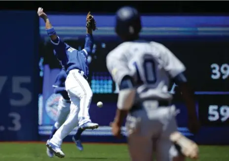  ?? RICK MADONIK/TORONTO STAR ?? Jays’ Darwin Barney can’t snare a short fly ball as Padres’ Alexei Ramirez heads to second during matinee action Wednesday at the Rogers Centre.