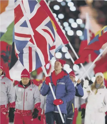  ??  ?? 0 Great Britain flag bearer Billy Morgan walks during the closing ceremony of the Winter Olympics.