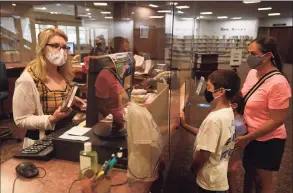  ?? Brian A. Pounds / Hearst Connecticu­t Media ?? Emily Boyle, her son Matthew, 10, and daughter Catherine, 7, check out books at the Trumbull Library on Sept. 28.
Participat­ion in digital and online programs is growing, and is expected to continue growing even after in- person programmin­g resumes at the Trumbull library.