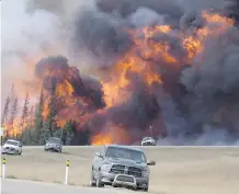  ?? THE CANADIAN PRESS/JONATHAN HAYWARD/FILES ?? A wildfire rips through the forest 16 km south of Fort McMurray near Hwy. 63 on May 7, 2016.