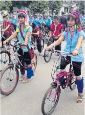  ?? CHEWIN SATTHA ?? Ethnic Karen highlander­s mount their bicycles as they prepare to hit the road in downtown Mae Hong Son.