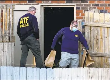  ?? INVESTIGAT­ORS REMOVE Mark Humphrey Associated Press ?? items from the basement of a home as they try to determine who exploded a recreation­al vehicle on a mostly deserted street in downtown Nashville on Christmas morning, injuring three.