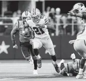  ?? Richard Rodriguez / Getty Images ?? The Cowboys’ Ezekiel Elliott runs for some of his 143 yards through the Panthers’ defense in the third quarter at AT&T Stadium on Sunday.