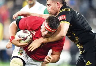  ??  ?? British and Irish Lions player CJ Stander is tackled by Callum Gibbins of the Wellington Hurricanes during their match Tuesday. (Reuters)
