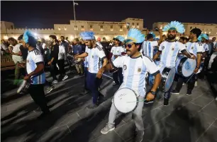  ?? — afp/reuters ?? Fans of Argentina, Brazil, England and Germany celebrate at a popular tourist area in Souq Waqif, Doha, ahead of the Fifa World Cup.