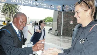  ?? Picture: FREDLIN ADRIAAN ?? PRECAUTION­ARY MEASURE: People entering Greenacres Hospital are being provided with hand-sanitiser and asked questions about overseas travel before being given the all-clear. Security official Malibongwe Nduzulwana assists Marguerite Smit, while sister Lynn Teengs looks on