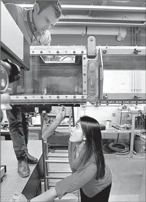  ?? AP/STEVEN SENNE ?? Engineer David Wade (top) and marine mammal biologist Christin Murphy position a seal whisker inside a water tunnel in a laboratory at the Naval Undersea Warfare Center, in Newport, R.I.