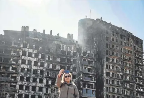  ?? // BIEL ALIÑO ?? Una mujer se toma una fotografía ayer ante el edificio incendiado en Valencia