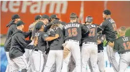  ?? GASTON DE CARDENAS/AP ?? Marlins celebrate after Miguel Rojas hits a game-winning RBI single in the 17th inning of Friday’s game against the Chicago Cubs.