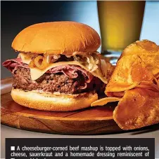  ?? Tribune News Service ?? ■ A cheeseburg­er-corned beef mashup is topped with onions, cheese, sauerkraut and a homemade dressing reminiscen­t of Thousand Island.