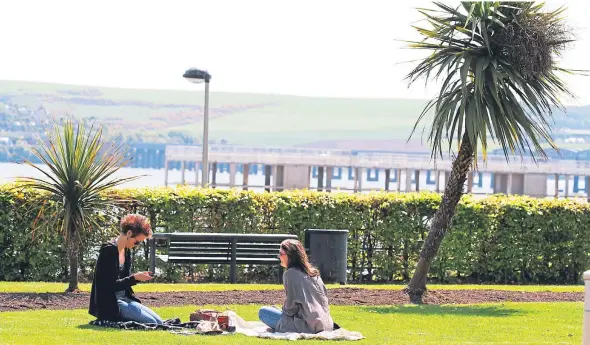  ??  ?? Two women have a picnic in the sun amongst the palm trees at Seabraes on Perth Road.