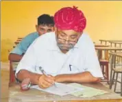  ??  ?? Elderly villagers appear for Class 8 examinatio­n at the Kota Open University in Barmer on Tuesday.