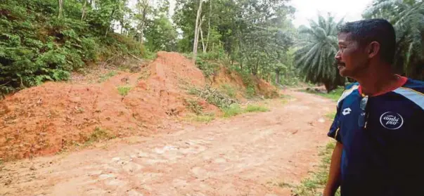  ?? [FOTO MUHAMMAD SULAIMAN/BH] ?? Penduduk kampung, Khairul Amirul Rashid menunjukka­n kawasan yang dipercayai akan dijadikan tanah perkuburan orang bukan islam di Kampung Bukit Cerakah, Kuala Selangor.