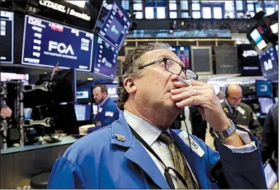  ?? AP/RICHARD DREW ?? Trader Steven Kaplan works Tuesday on the floor of the New York Stock Exchange, where industrial and tech stocks fell on fears of an all-out trade war between the United States and China.