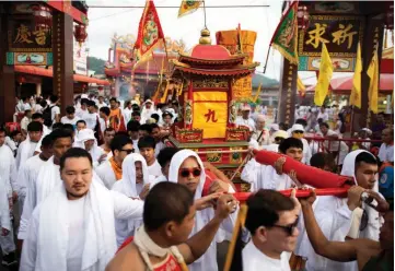  ??  ?? Devotees of the Loem Hu Thai Su shrine taking part in a parade during the annual Vegetarian Festival in Phuket.