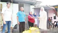  ??  ?? MARIUS (dua dari kiri) mewakilkan isterinya untuk menerima sumbangan YNJ daripada Norlidah (kanan).