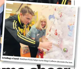  ??  ?? Lending a hand Matthew Knox helps nurse Mags Colbron decorate the tree.