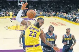  ?? [AP PHOTO] ?? Lakers forward LeBron James, left, follows through on a dunk as Nuggets forward Paul Millsap, center, and guard Monte Morris watch during the first half Oct. 2 in Los Angeles. James was named The Associated Press Male Athlete of the Year on Thursday.